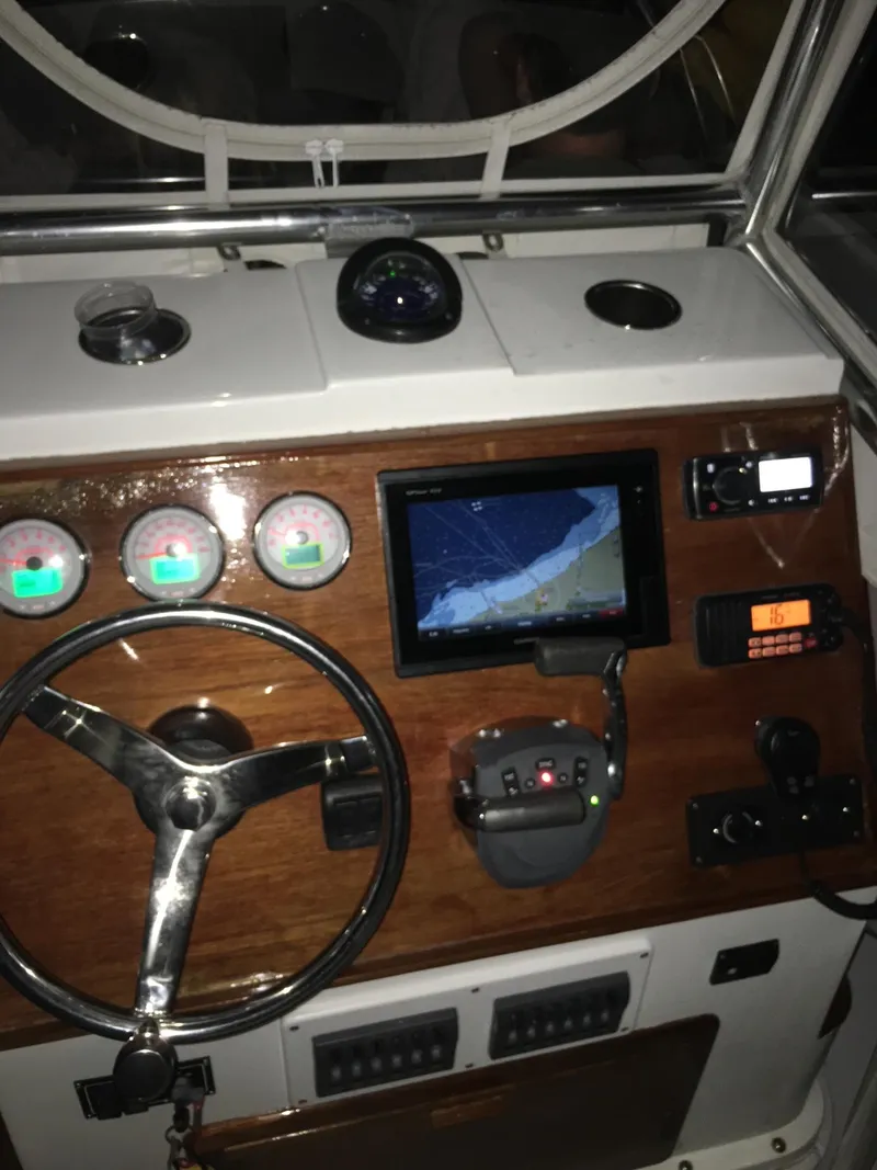 Slide: The Image of 1991 Mako 241 boat dashboard with steering wheel, gauges, GPS, and radio equipment. - 31
