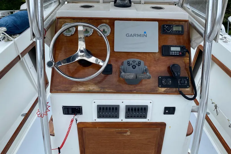 Slide: The Image of 1991 Mako 241 boat dashboard with Garmin navigation and communication equipment. - 33