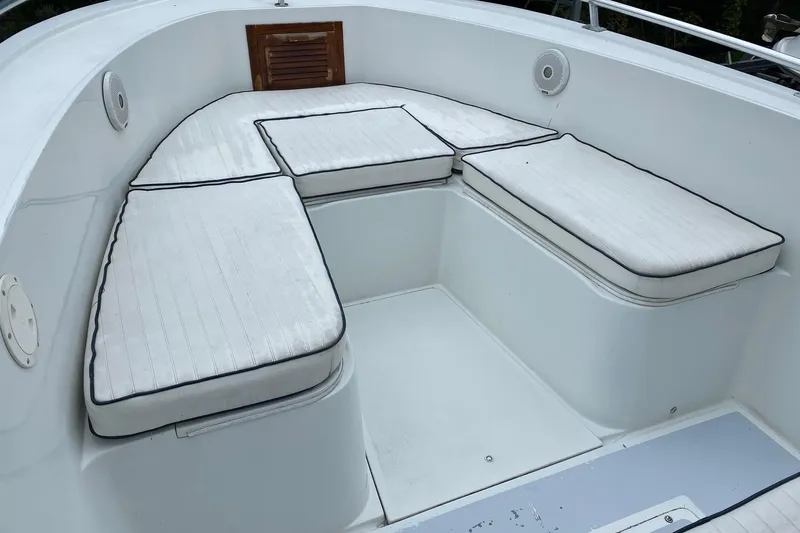 Slide: The Image of 1991 Mako 241 boat interior with white cushioned seating and wooden hatch. - 35