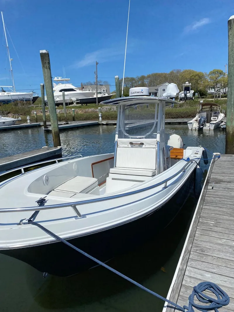 Slide: The Image of 1991 Mako 241 boat docked at marina under clear blue sky. - 4