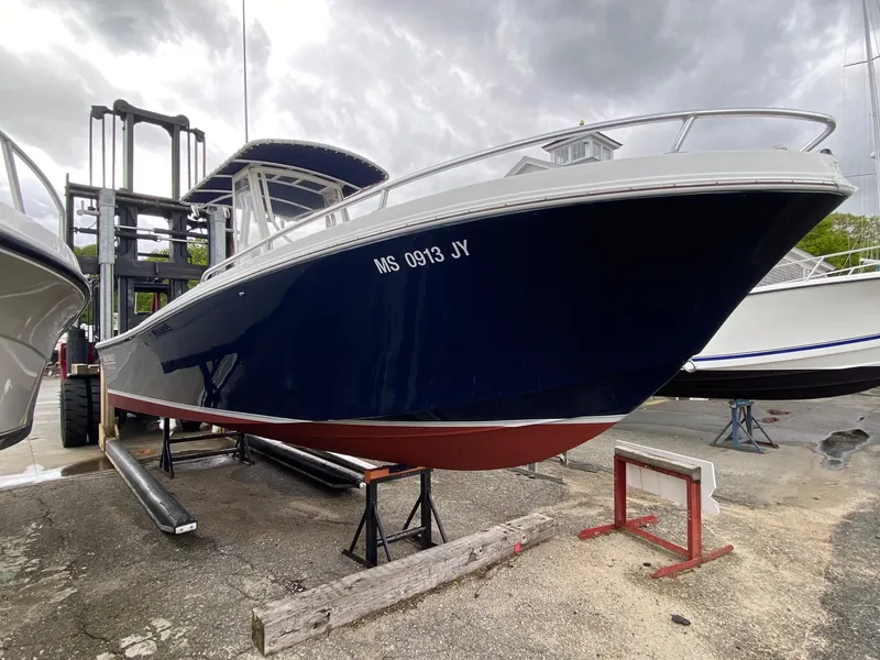 Slide: The Image of 1991 Mako 241 boat on dry dock, dark blue hull, overcast sky. - 9