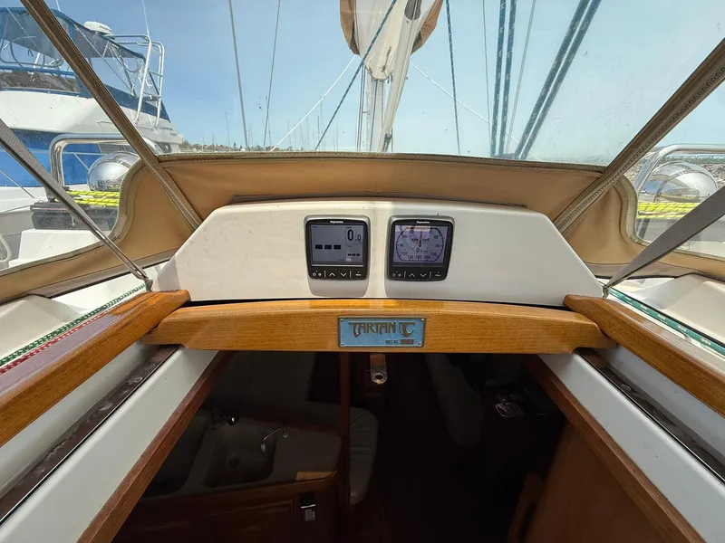 Slide: The Image of Cockpit view of a 2012 Tartan 4000 sailboat, featuring navigation instruments and wooden trim. - 29