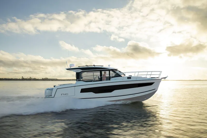 Slide: The Image of 2026 Jeanneau NC 1095 S2 cruising on calm waters at sunset. - 1