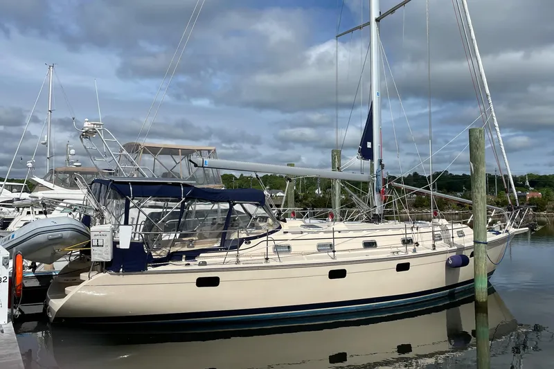 The Image of 2021 Island Packet 439 sailboat docked in a marina under cloudy skies. - 0