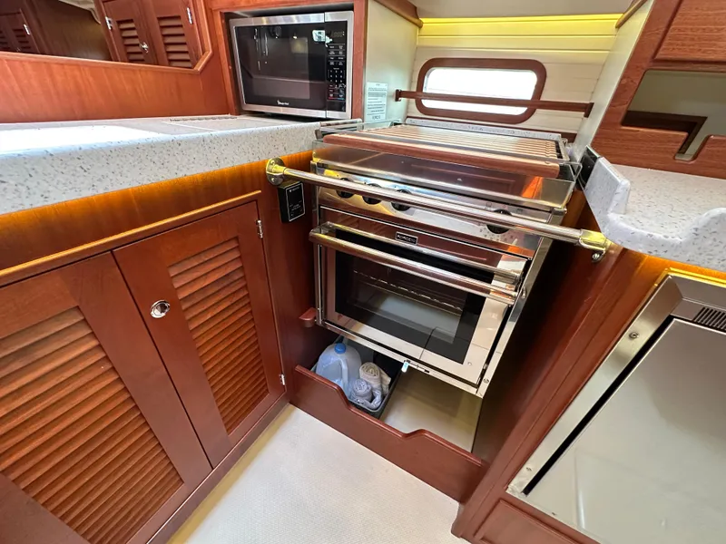 Slide: The Image of 2021 Island Packet 439 yacht kitchen with modern appliances and wooden cabinetry. - 31