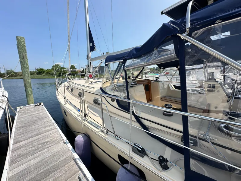 Slide: The Image of 2021 Island Packet 439 sailboat docked, featuring sleek design and blue canopy. - 5