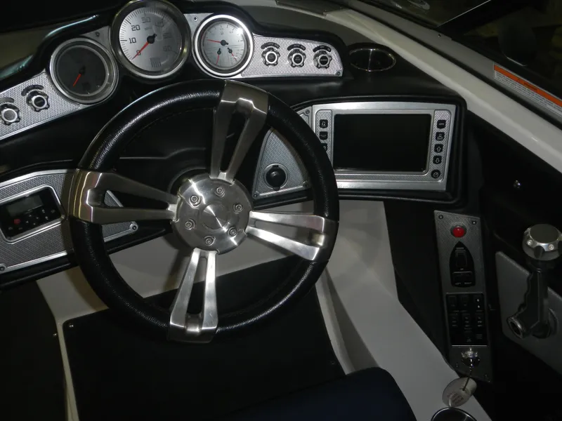 Slide: The Image of 2013 MasterCraft X30 boat dashboard with steering wheel and control panel. - 12