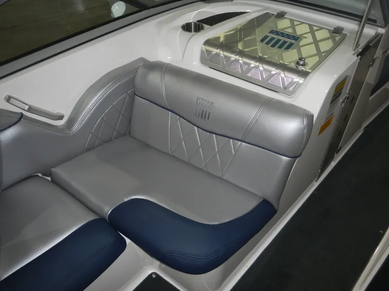 Slide: The Image of 2013 MasterCraft X30 interior with silver and blue seating, featuring diamond stitching and cup holder. - 15