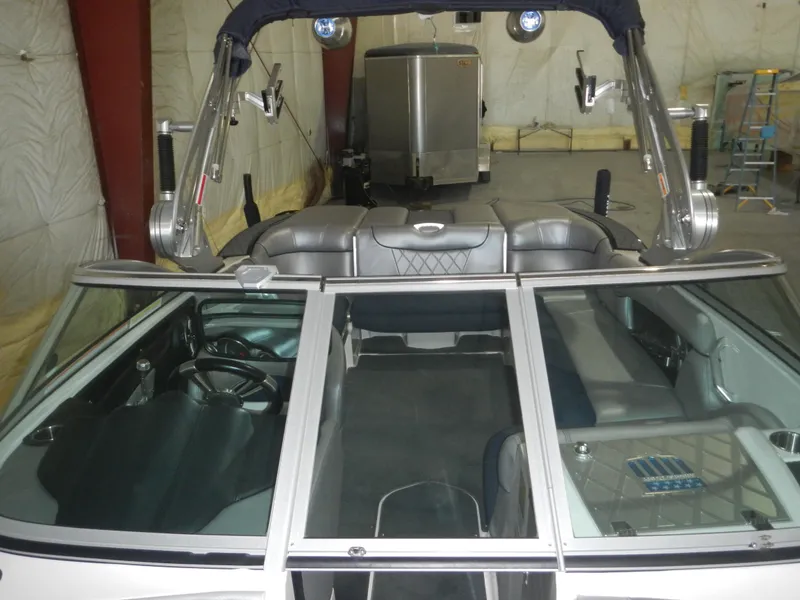 Slide: The Image of 2013 MasterCraft X30 boat interior with seating and steering wheel in a storage facility. - 18