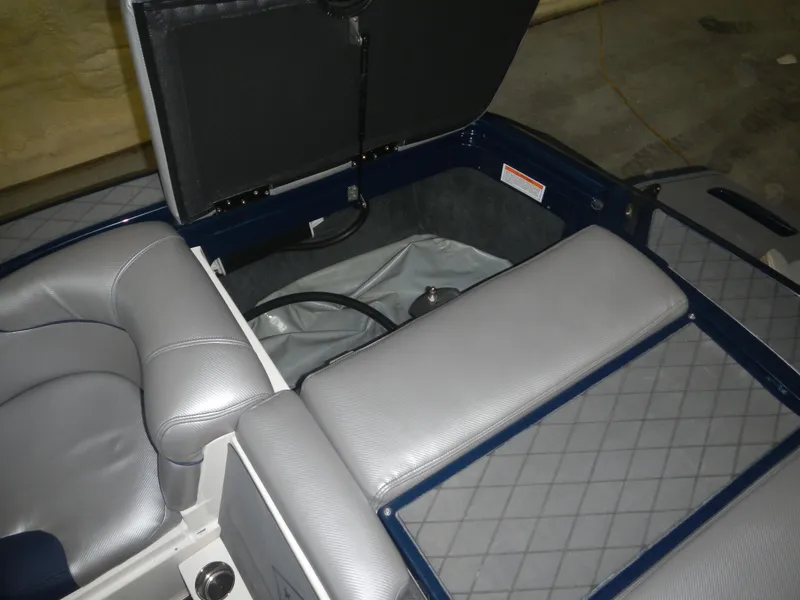 Slide: The Image of 2013 MasterCraft X30 boat interior with open storage compartment and gray seating. - 21