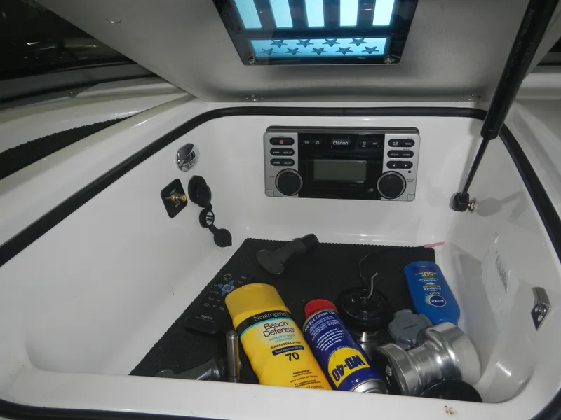 Slide: The Image of 2013 MasterCraft X30 storage compartment with radio and maintenance supplies. - 24