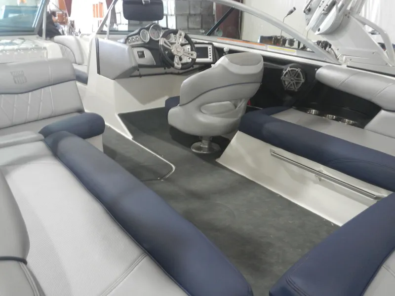 Slide: The Image of 2013 MasterCraft X30 boat interior with gray and blue seating, modern dashboard, and steering wheel. - 7