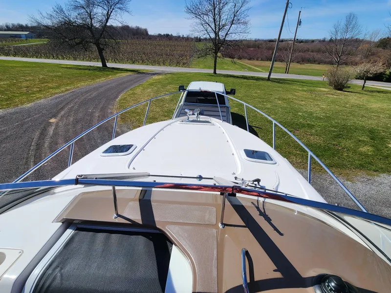 Slide: The Image of 2005 Regal Commodore 2765 boat on trailer, parked on a rural driveway. - 16
