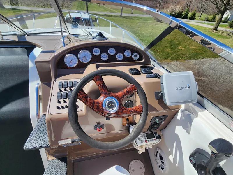 Slide: The Image of 2005 Regal Commodore 2765 boat dashboard with Garmin GPS and wood-accented steering wheel. - 19