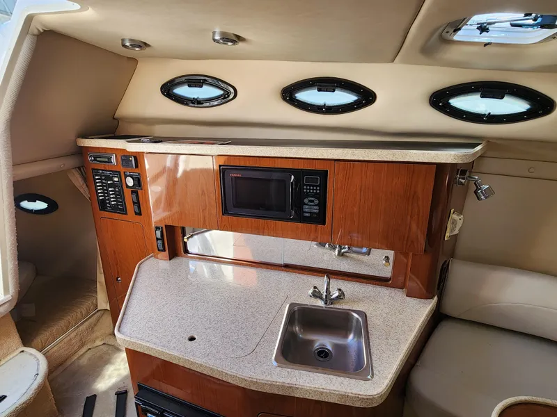 Slide: The Image of 2005 Regal Commodore 2765 boat interior with kitchenette, sink, and microwave. - 21