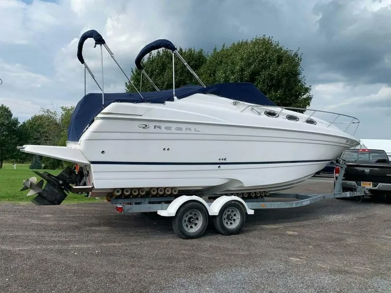 Slide: The Image of 2005 Regal Commodore 2765 boat on trailer, parked outdoors under cloudy sky. - 4