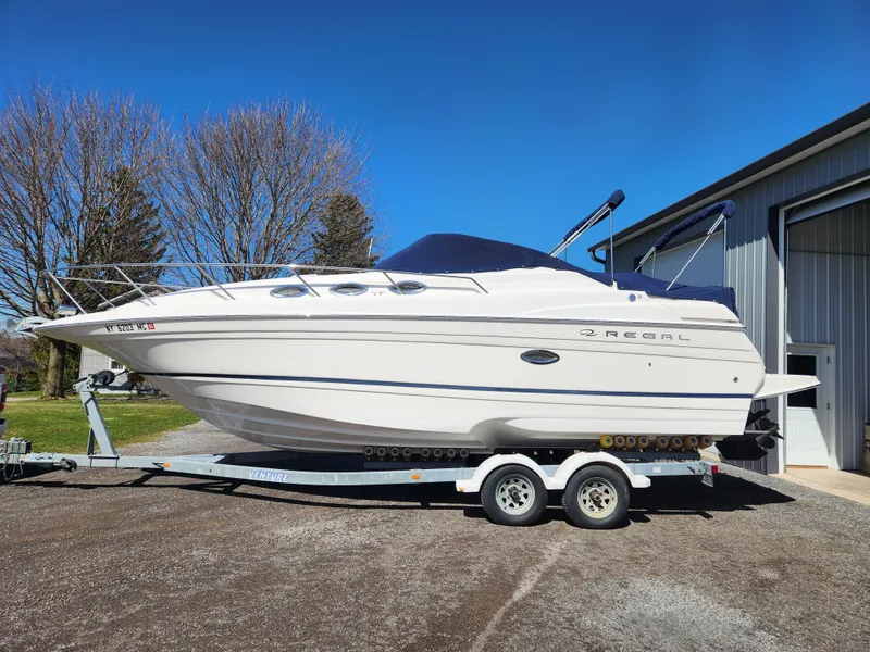 Slide: The Image of 2005 Regal Commodore 2765 boat on trailer, parked outdoors near a building. - 6
