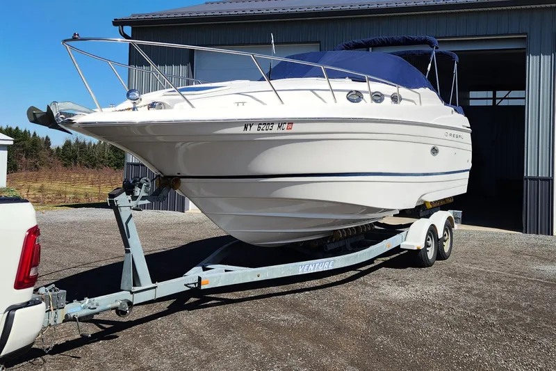 Slide: The Image of 2005 Regal Commodore 2765 boat on trailer, parked outside a metal building. - 9
