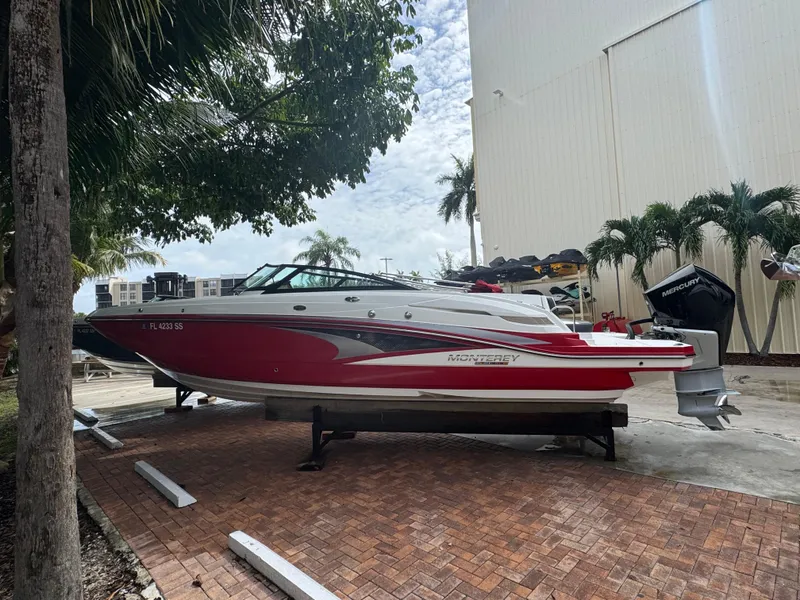 The Image of 2020 Monterey M65 boat on display, red and white design, parked outdoors. - 11