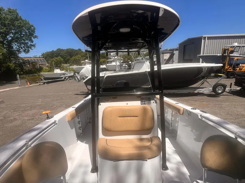 Slide: The Image of 2018 Sportsman Open 232 Center Console boat with tan seating, parked outdoors. - 2