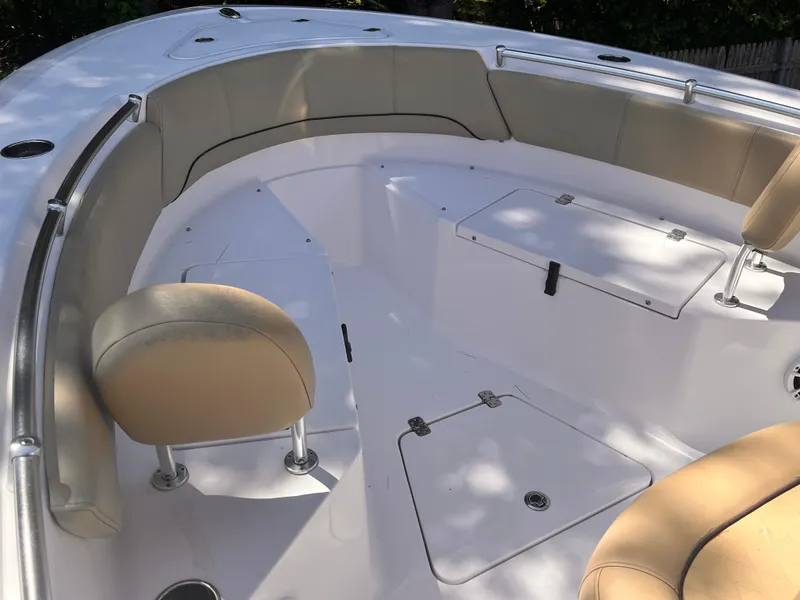 Slide: The Image of 2018 Sportsman Open 232 Center Console boat interior with cushioned seating and storage compartments. - 6