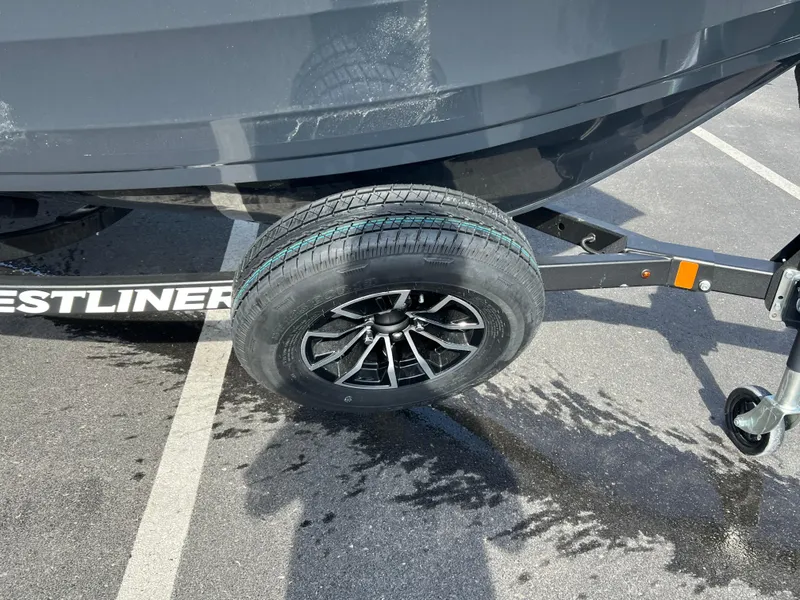 Slide: The Image of 2025 Crestliner 1650 Kodiak boat trailer with black wheel on asphalt. - 7