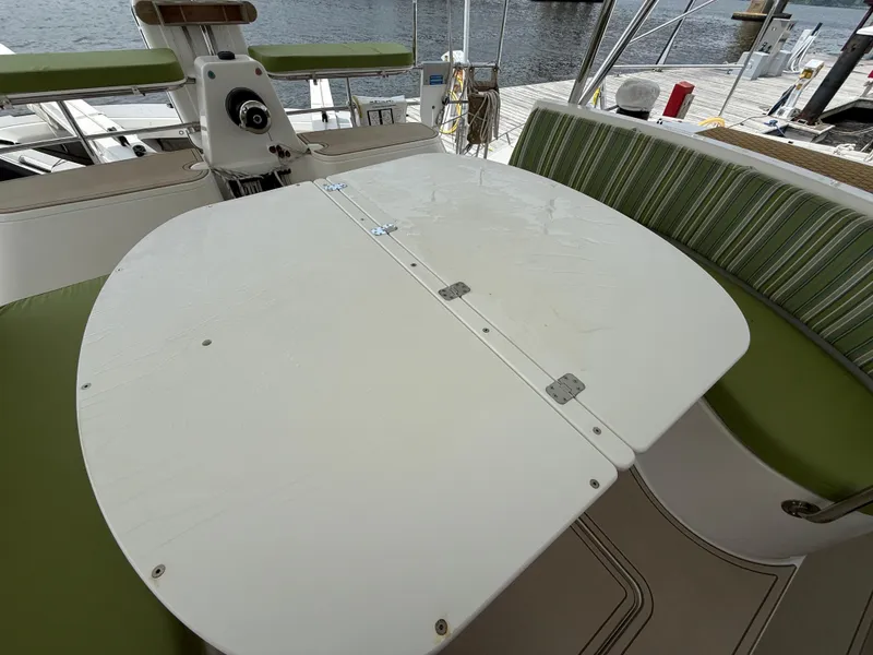 Slide: The Image of Antares 44GS 2021 yacht cockpit with foldable table and green cushioned seating. - 14