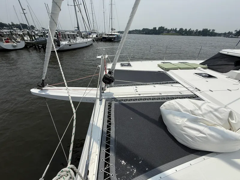 Slide: The Image of 2021 Antares 44GS catamaran docked at marina, featuring spacious deck and netting. - 26