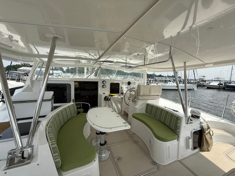 Slide: The Image of 2021 Antares 44GS yacht cockpit with green seating, table, and helm, docked at marina. - 38