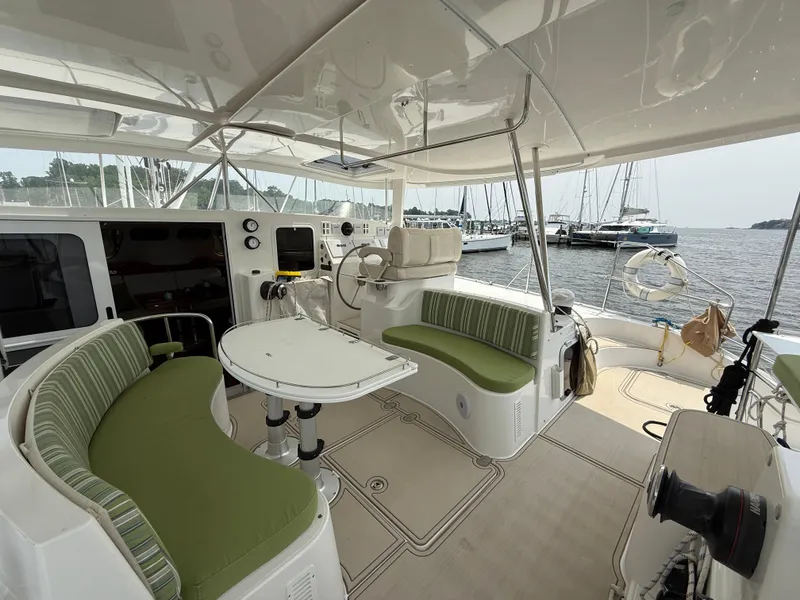 Slide: The Image of Spacious cockpit of 2021 Antares 44GS yacht with green seating and marina view. - 40