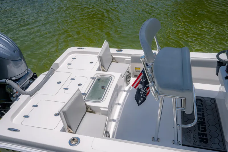 Slide: The Image of 2024 Contender 26 Bay boat interior with seating and motor, on calm water. - 10