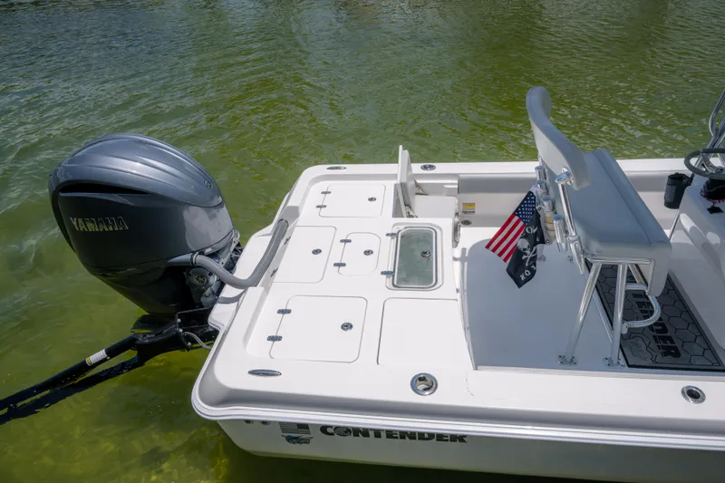 Slide: The Image of 2024 Contender 26 Bay boat with Yamaha outboard engine on calm water. - 11