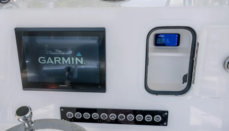 Slide: The Image of 2024 Contender 26 Bay boat dashboard with Garmin display and control panel. - 16