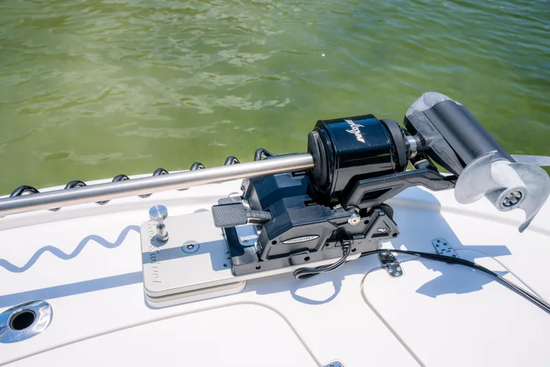 Slide: The Image of 2024 Contender 26 Bay boat with trolling motor on deck, near green water. - 19