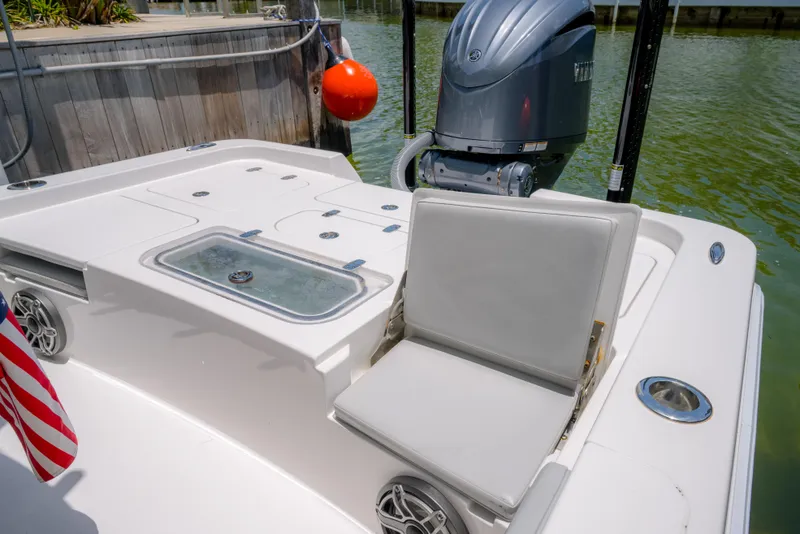 Slide: The Image of 2024 Contender 26 Bay boat with outboard motor and seating, docked by the water. - 27