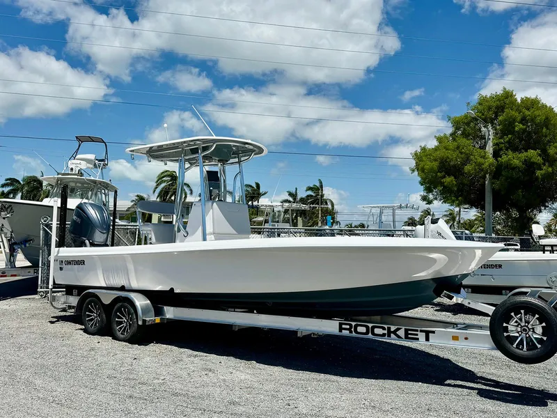 Slide: The Image of 2024 Contender 26 Bay boat on a trailer under a clear blue sky. - 5