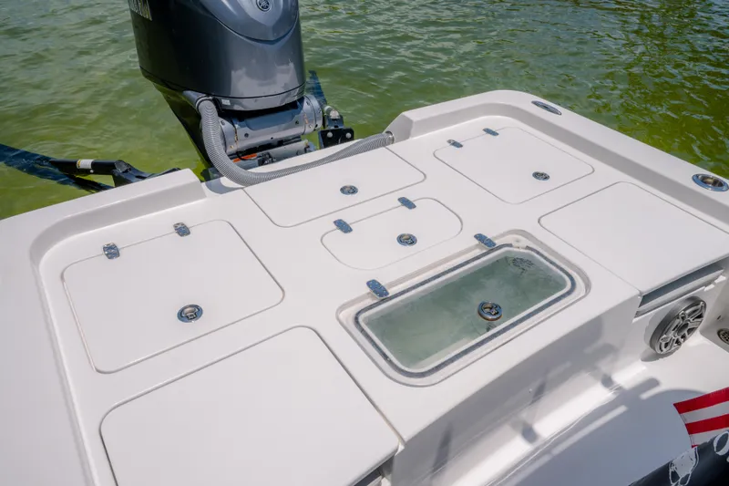 Slide: The Image of 2024 Contender 26 Bay boat deck with storage compartments and outboard motor. - 8