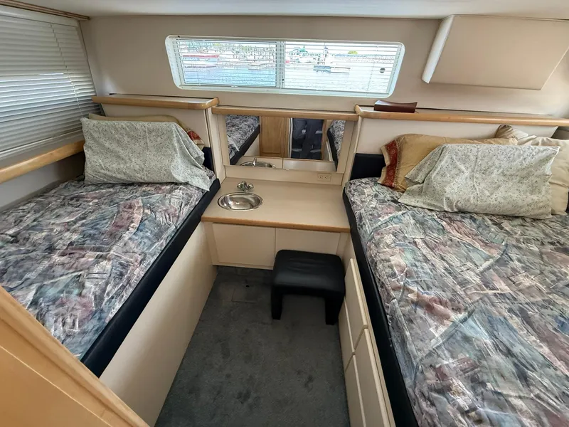 Slide: The Image of 1996 Carver 325 Aft Cabin interior with twin beds and a small sink. - 16