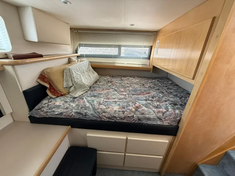 Slide: The Image of 1996 Carver 325 Aft Cabin interior with bed, wooden cabinets, and window blinds. - 18