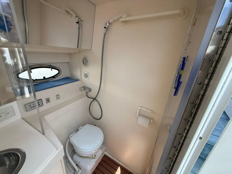 Slide: The Image of 1996 Carver 325 Aft Cabin bathroom with shower, toilet, and sink. - 25
