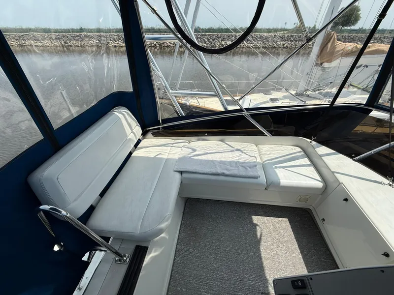 Slide: The Image of 1996 Carver 325 Aft Cabin interior with white seating and panoramic windows. - 28