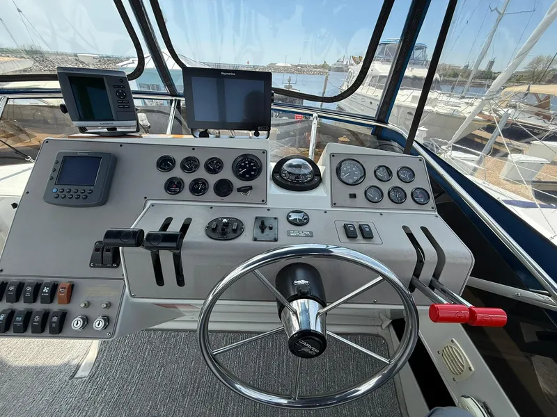 Slide: The Image of 1996 Carver 325 Aft Cabin helm with steering wheel, gauges, and navigation equipment. - 32
