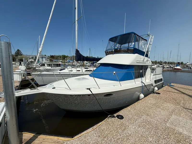 Slide: The Image of 1996 Carver 325 Aft Cabin yacht docked at marina under clear blue sky. - 4