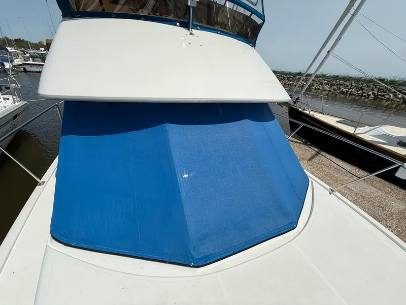 Slide: The Image of 1996 Carver 325 Aft Cabin boat with blue canvas cover docked at marina. - 6
