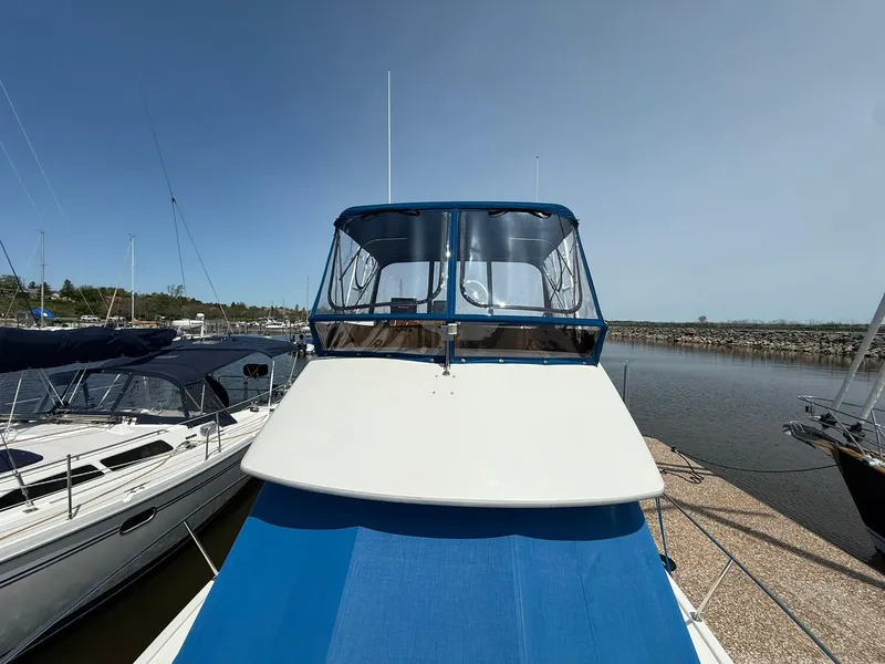 Slide: The Image of 1996 Carver 325 Aft Cabin boat docked at marina, clear sky background. - 7