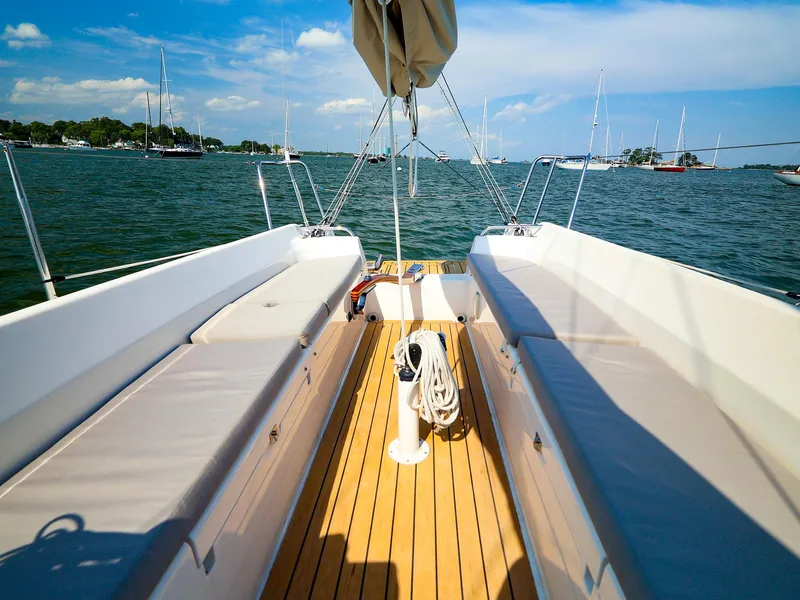 Slide: The Image of 2022 J Boats J/9 sailboat cockpit with wooden deck and cushioned seating on a sunny day. - 20