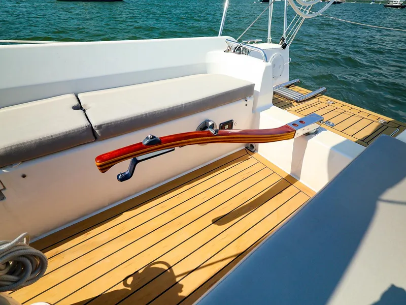 Slide: The Image of 2022 J Boats J/9 sailboat cockpit with wooden tiller and cushioned seating. - 22
