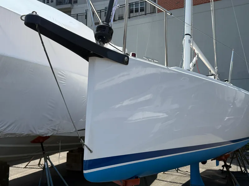 Slide: The Image of 2022 J Boats J/9 sailboat bow with sleek white hull and blue stripe. - 29