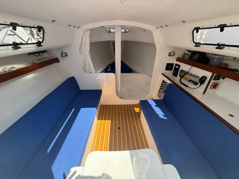 Slide: The Image of Interior of 2022 J Boats J/9 sailboat with blue seating and wooden flooring. - 42