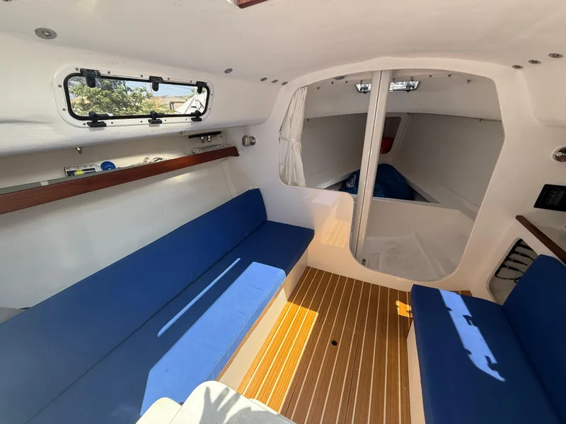 Slide: The Image of Interior of 2022 J Boats J/9 sailboat with blue seating and wood flooring. - 43